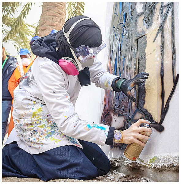 Saudi street artist working on a mural